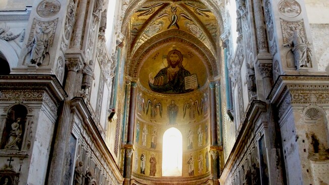 La nave interior de la catedral basílica de Cefalú, que deja ver un elaborado mural en el que se observan Cristo, ángeles y los doce discípulos