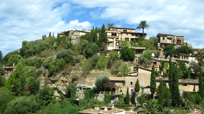 A lush hillside with several Spanish old houses