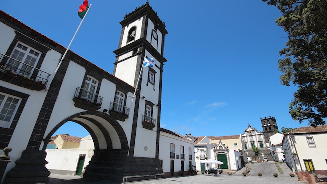 An archway of a building featuring a clock tower in the town center An archway of a building featuring a clock tower in the town center
