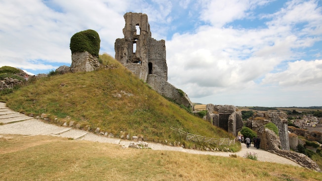 The stone ruins of Corfe Castle stands on the top of a grassy hill