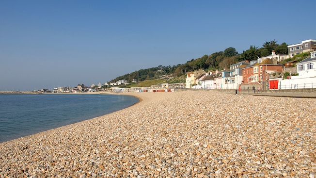 A tranquil pebble beach lined with multi story Queen Anne buildings A tranquil pebble beach lined with multi story Queen Anne buildings