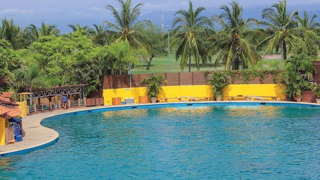 Mountains and palm trees surround a pool area Mountains and palm trees surround a pool area