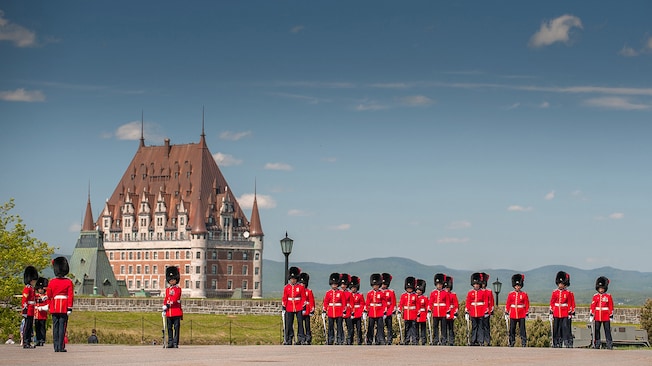 Um grupo de soldados em trajes cerimoniais perto de um palácio Um grupo de soldados em trajes cerimoniais perto de um palácio