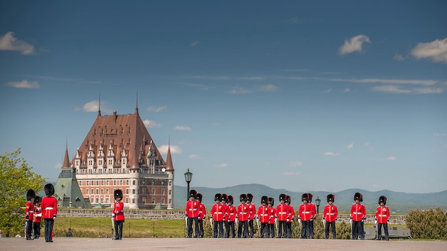 Members of the guard carrying swords and dressed in classic uniforms stand outside a citadel Members of the guard carrying swords and dressed in classic uniforms stand outside a citadel