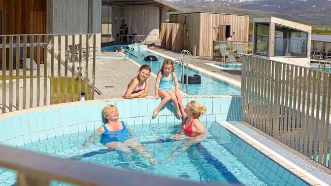 2 women and 2 young girls lounging in and around the shallow waters of an outdoor whirlpool spa 2 women and 2 young girls lounging in and around the shallow waters of an outdoor whirlpool spa