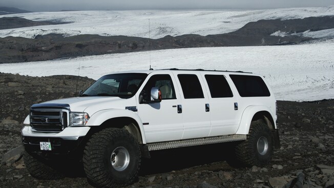Uma caminhonete fantástica Ford Excursion do último modelo com 6 portas em uma paisagem de montanha nevosa