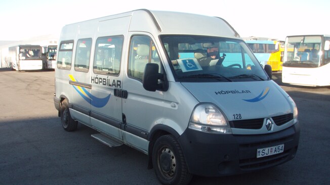 The front and side of a late model van with a disabled person placard taped to windsheild