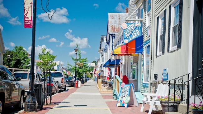 Cars line the sidewalk of a shopping district with low rise A frame buildings in a small town Cars line the sidewalk of a shopping district with low rise A frame buildings in a small town