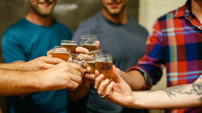 A group of men toast with glasses of beer