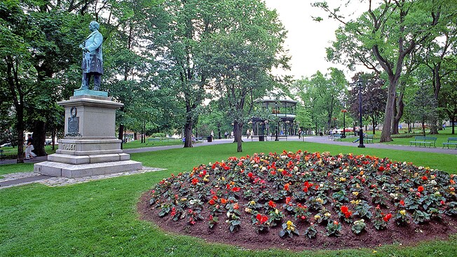 A city park with benches, a gazebo, a flower bed and a bronze statue A city park with benches, a gazebo, a flower bed and a bronze statue
