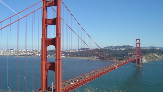 The Golden Gate Bridge with cars on it, stretching across the bay to land on the other side