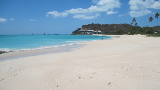 Um homem se curva na linha de água em uma praia vazia Um homem se curva na linha de água em uma praia vazia