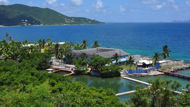 A resort building surrounded by water has several walking bridges to access nearby island locations
