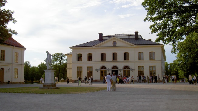 Groups of people standing outside a multi window rococo theater Groups of people standing outside a multi window rococo theater