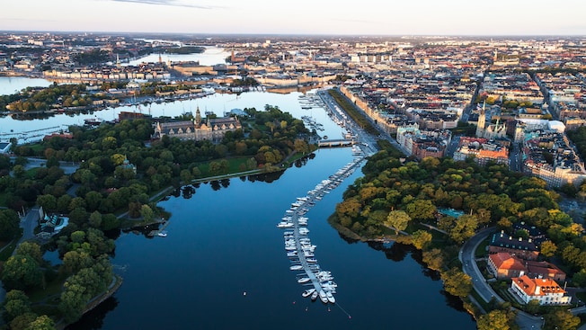 A dock crowded with boats in a waterway that runs through a city A dock crowded with boats in a waterway that runs through a city