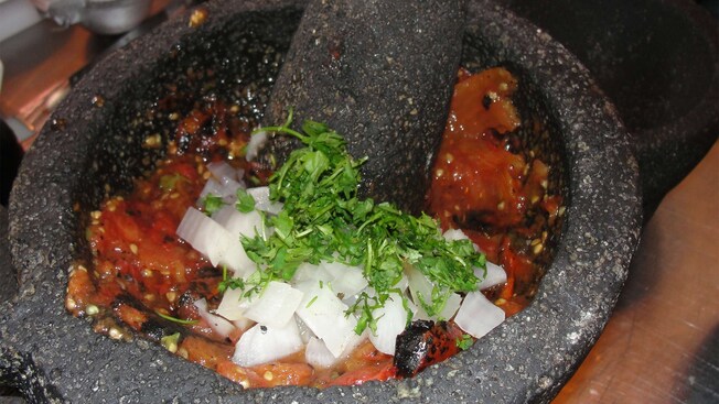 Los ingredientes de una salsa en un molcajete se muelen con un mortero