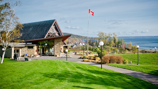 A building is flanked by a lawn with lampposts and a Canadian flag on a flagpole A building is flanked by a lawn with lampposts and a Canadian flag on a flagpole