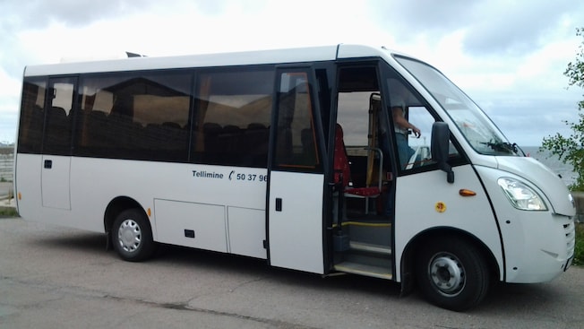 A man climbing into the drivers seat of an empty bus A man climbing into the drivers seat of an empty bus
