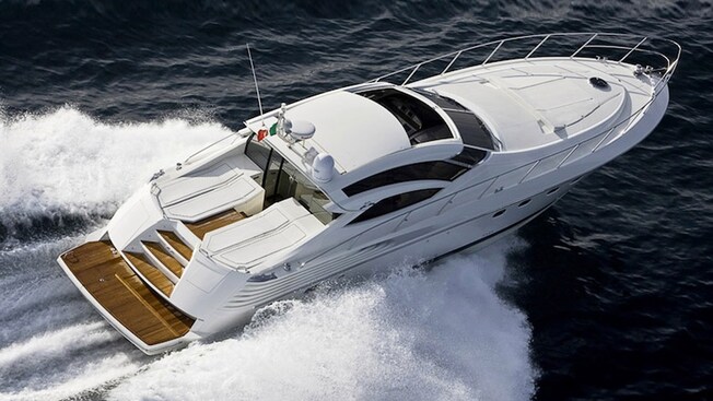 A speeding yacht has hardwood stairs leading to its cabin and tinted windows