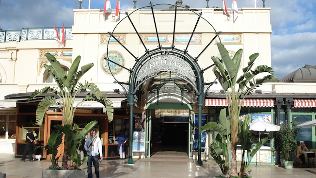 Rectangular building with a single entrance covered by a metal awning and flanked by food stands Rectangular building with a single entrance covered by a metal awning and flanked by food stands