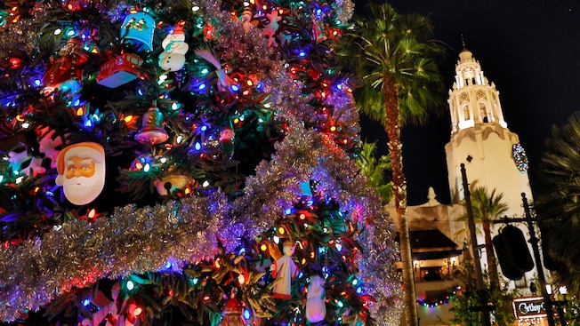 A decorated Christmas tree near a cathedral and palm trees