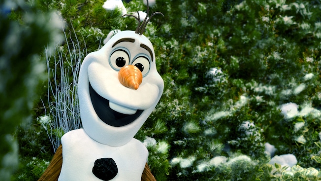 Olaf smiling in front of snow-covered trees at Disney California Adventure Park