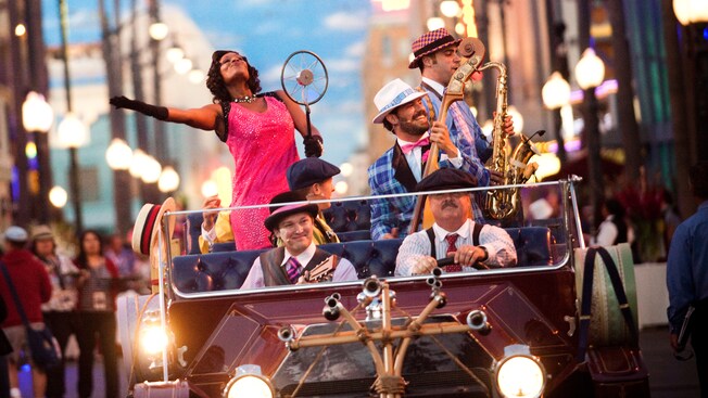 The members of Five & Dime perform music from an antique convertible car