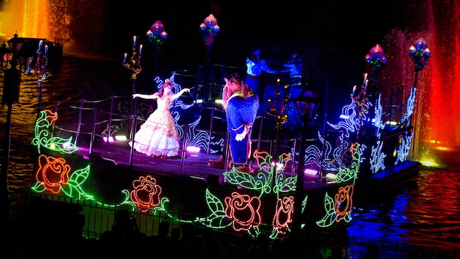 La bella, Belle, y la bestia bailan en un carro alegórico romántico decorado con rosas de Fantasmic!