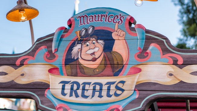 Un letrero colorido en Fantasy Faire que dice "Maurice’s Treats"