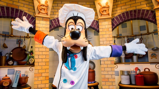 Goofy wearing a chefâs ensemble presents his kitchen