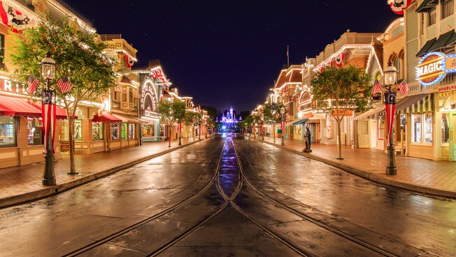 Festive lights illuminating Disneyland Park as Main Street, U.S.A. leads to Sleeping Beauty Castle