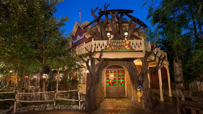 Tigger, Pooh, tarros de miel y otras decoraciones con temática del Bosque de los Cien Acres bordean la entrada de Pooh Corner