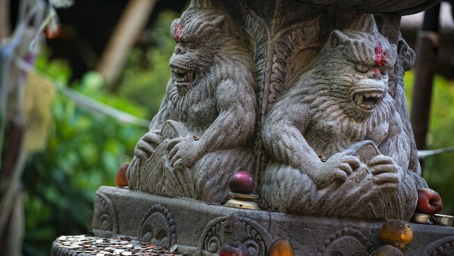 Dos esculturas de Yeti con dientes afilados talladas en un altar