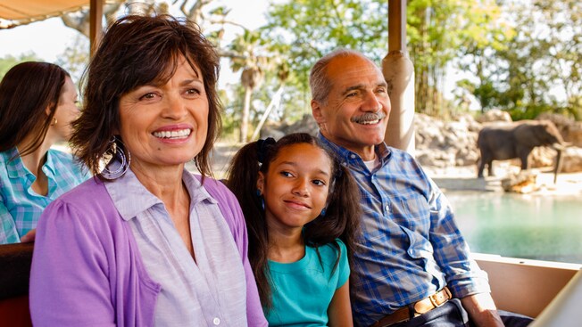 Abuelos y su nieta sentados en el autobús de safari descubierto