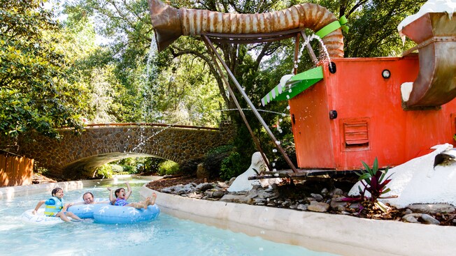 A dad and his 2 kids enjoy the water gushing from the 
