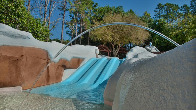 Three small side-by-side downhill waterslides that empty into a wading pool 