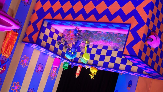 An upside-down bathtub with geometric patterns and Figment taking a bath