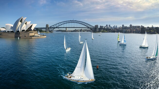 Boats sailing near the Sydney Opera House and Sydney Harbour Bridge during Soarin’ Around the World