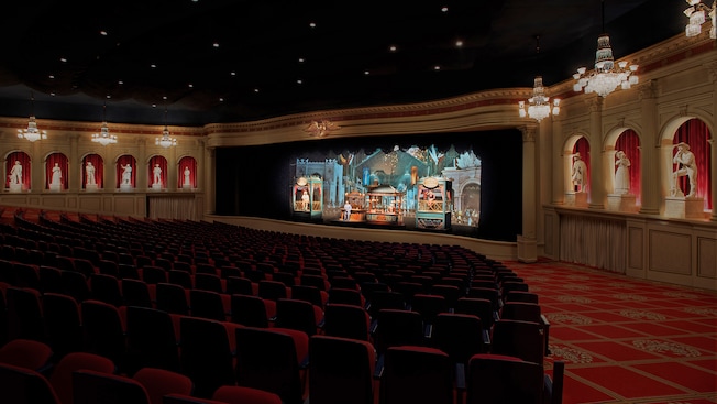 The theater at The American Adventure with rows of seats, a colorful stage and statues on the walls