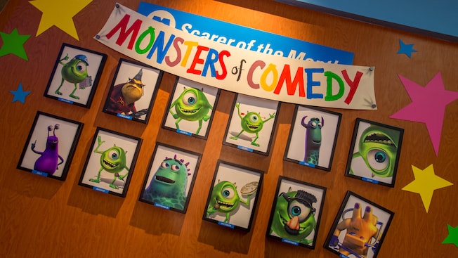 Framed pictures of the Monsters of Comedy on a wall at the Monsters, Inc. Laugh Floor attraction