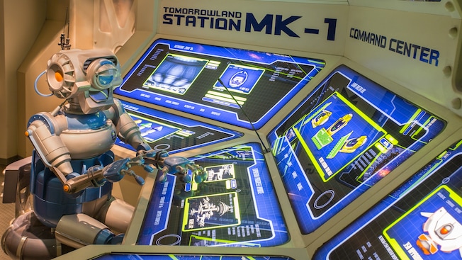 A robot controls computers screens at the Command Center in Space Mountain