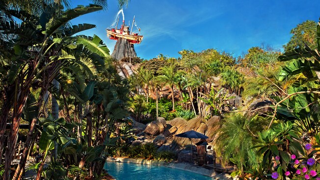 Castaway Creek graced by tropical trees, with iconic Miss Tilly atop Mount Mayday in the background