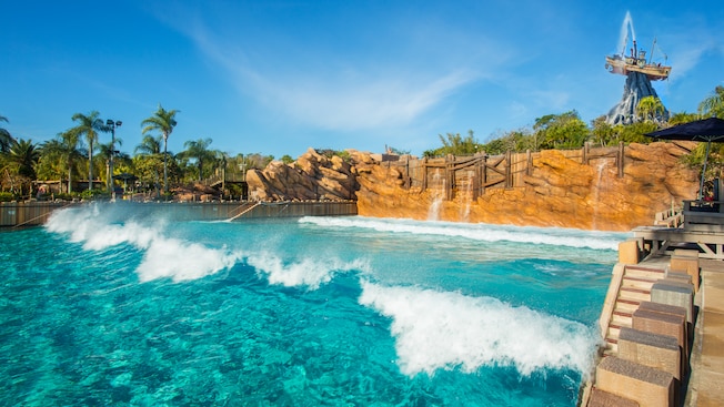 Waves break in Disney's Typhoon Lagoon Surf Pool with Mount Mayday in the background