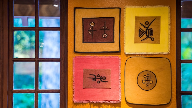 4&nbsp;obras de arte africanas auténticas cuelgan de la pared de la cafetería Creature Comforts en Discovery Island