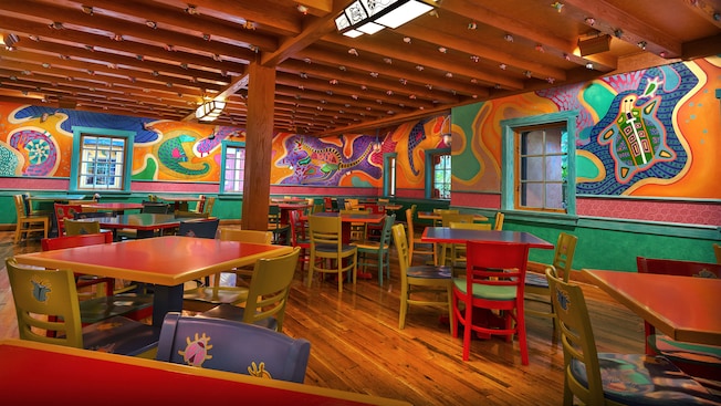 Square, colorful tables next to stylized animal murals