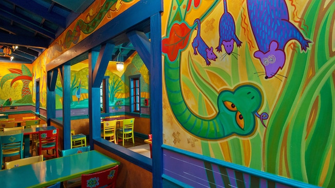Two separate dining areas with colorful animal murals separated by a half wall