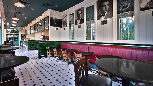 Seating area inside Cookes of Dublin, with black-and-white portraits and red banquettes