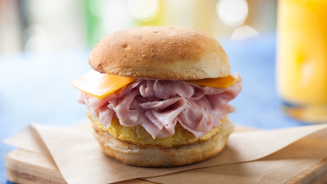 The ham, egg 'n' cheddar breakfast sandwich, with orange juice in the background