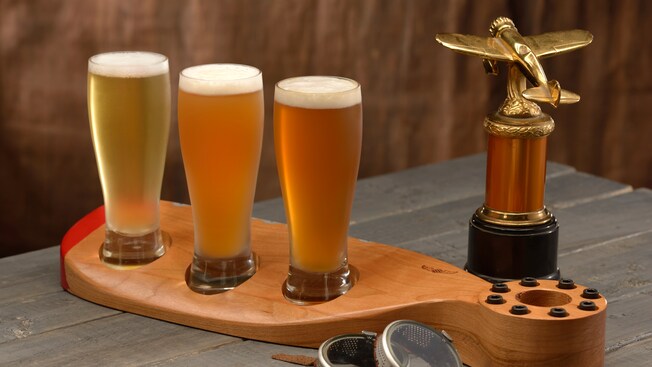 A flight of 3 beers served on a wooden airplane propeller