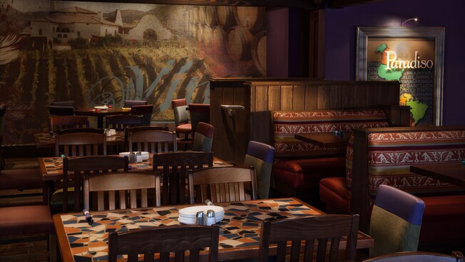 A travel poster and wall mural of a winery overlook colorfully tiled tables and wooden booths